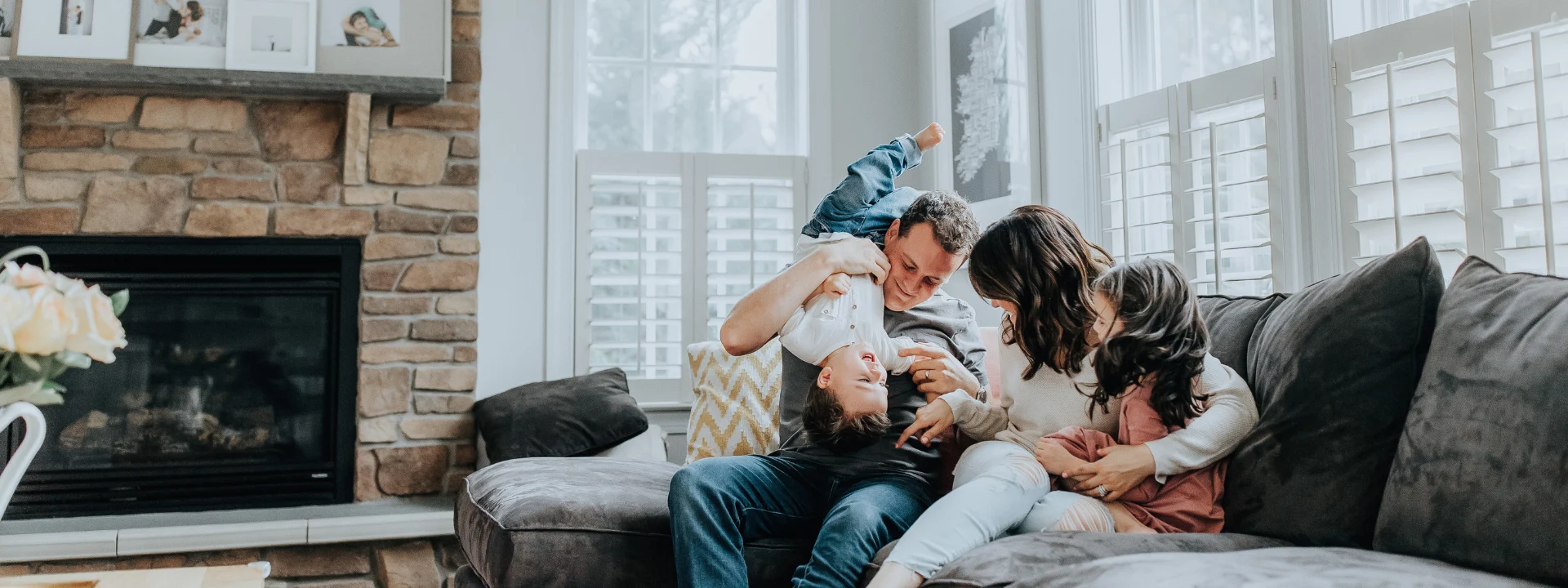 Familia con dos hijos jugando en el salón de casa, seguro de hogar