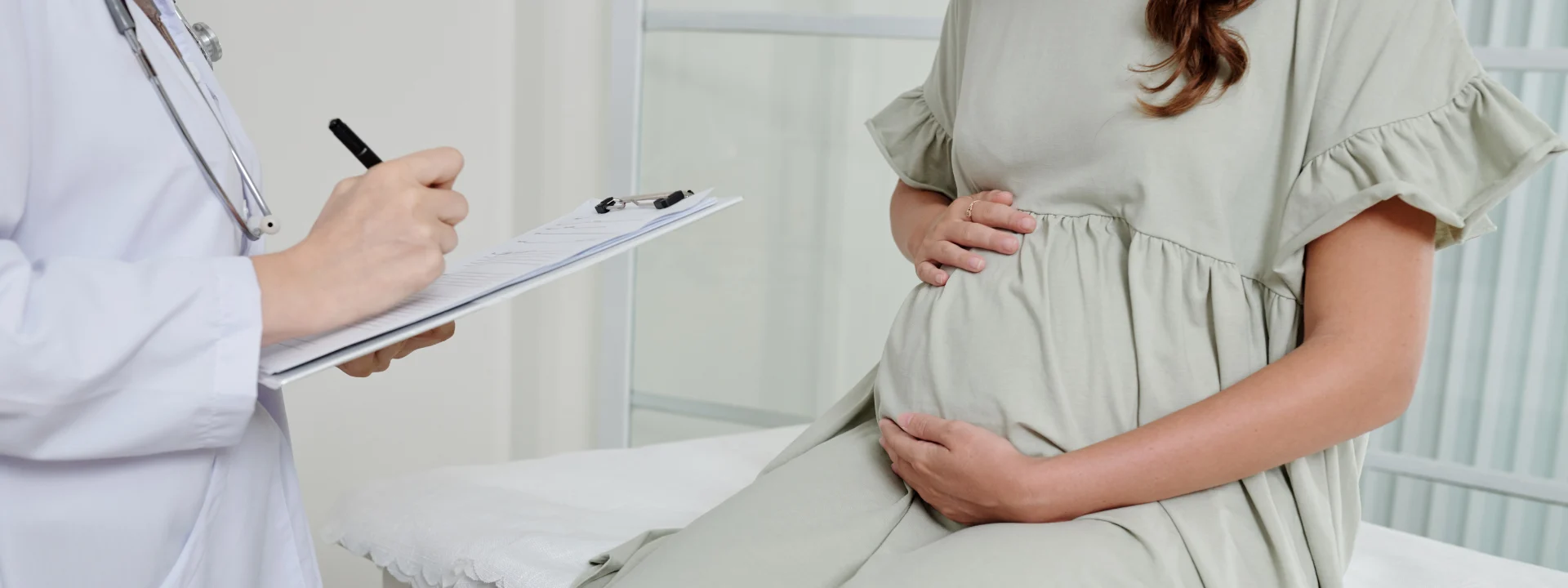 Mujer embarazada en una consulta médica, seguro de salud para embarazadas