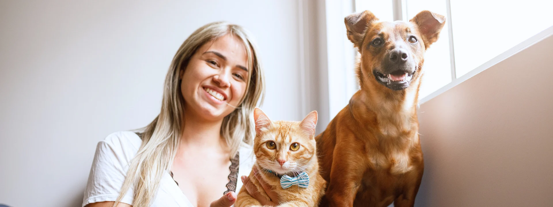 Mujer con su gato y su perro en casa, seguro para mascotas
