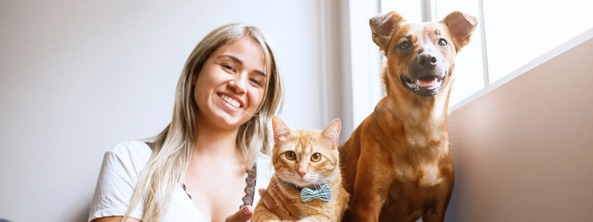 Una joven con su perro y su gato en brazos